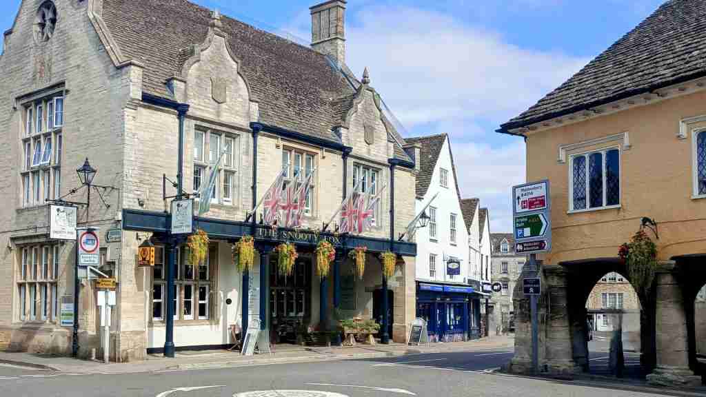 Tetbury High Street with boutiques and Cotswold stone architecture. Tetbury High Street lined with Cotswold stone buildings, antique shops, designer boutiques and cafés, reflecting the town’s medieval and Georgian origins and thriving commerce
